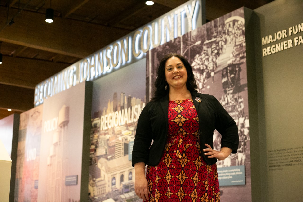 Historian Mary McMurray standing in front of a museum exhibit.