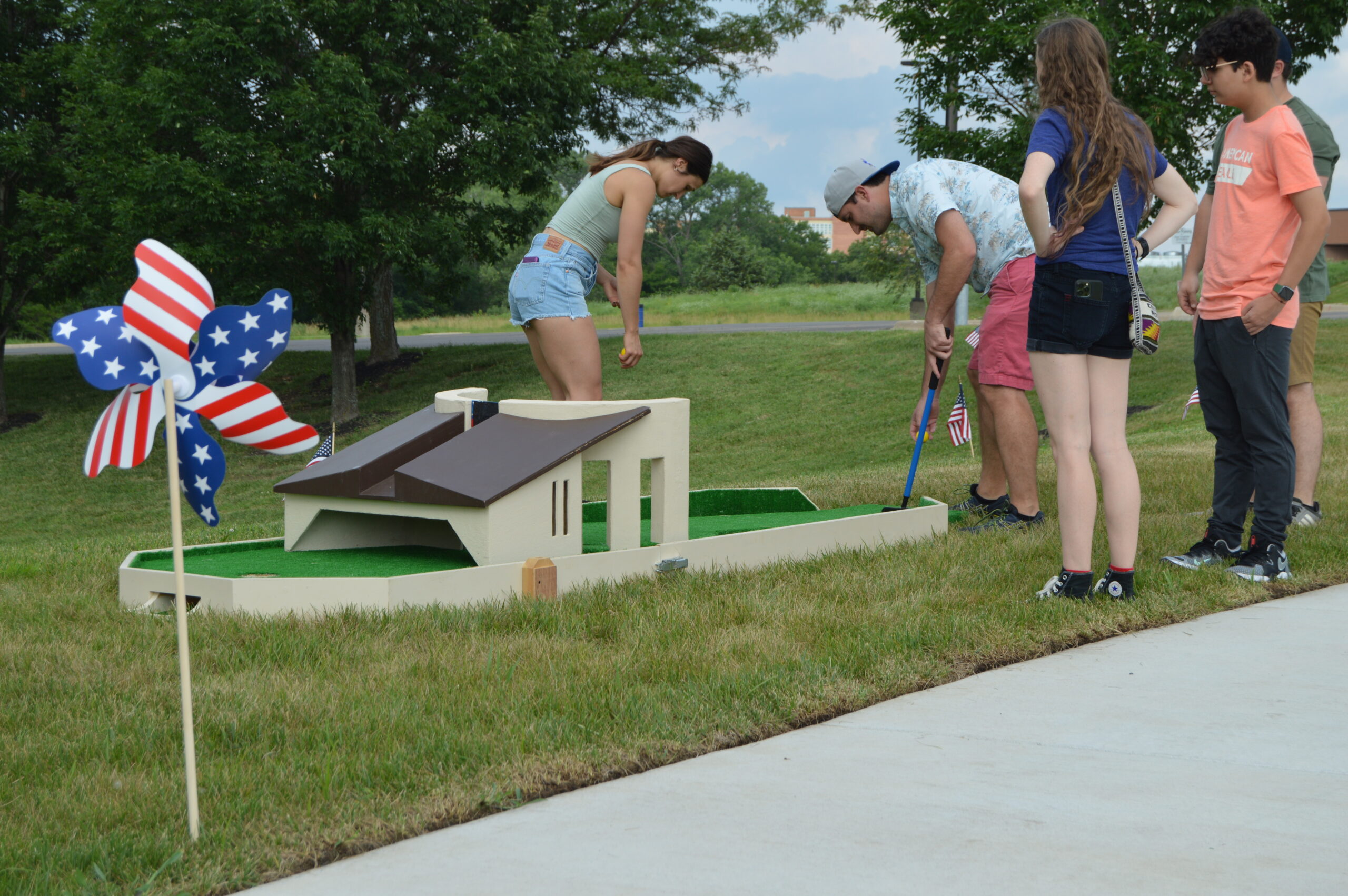 people participating in mini golf with the Dole Hole, which includes a miniature Dole Institute