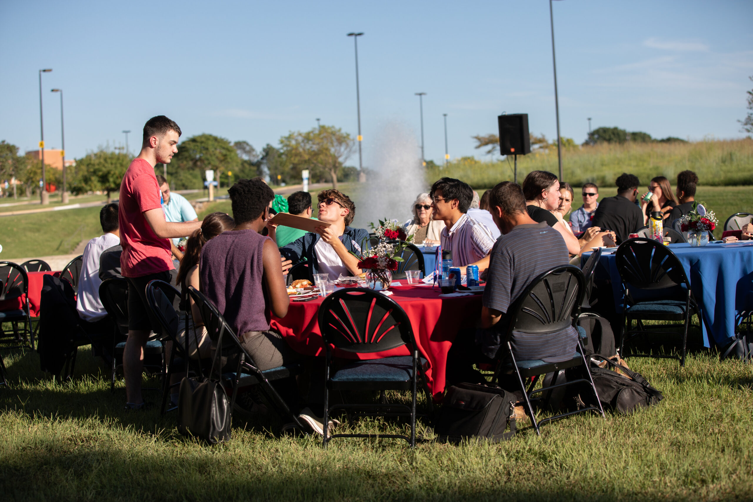 people eating dinner at tables on the lawn outside the Dole Institute of Politics