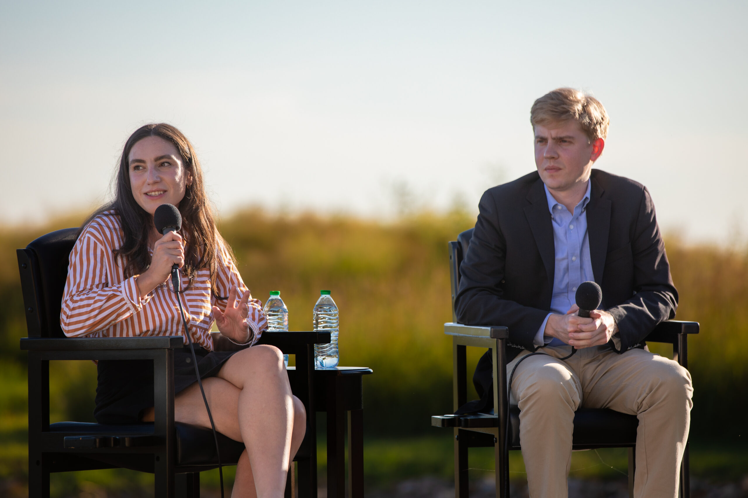 two people are seated on a stage