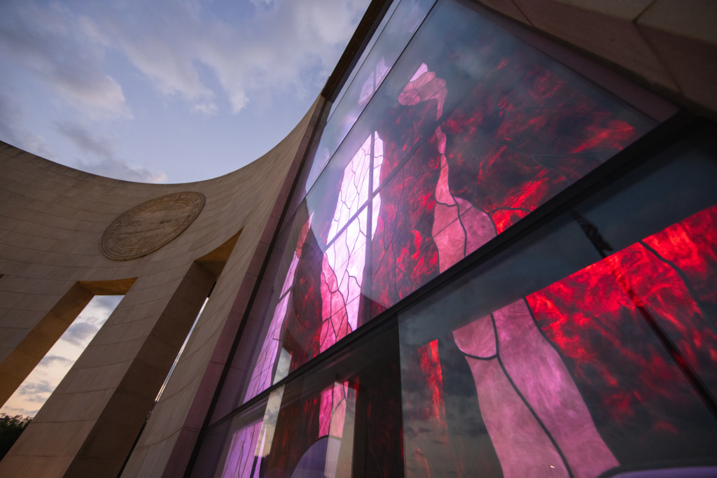 The Stained Glass American Flag Window on the front of the Dole Institute is illuminated during the evening hours on July 4, 2021.