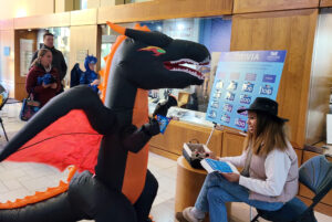 A child dressed in an inflatable dragon costume answers trivia questions at the Dole Institute on October 30, 2023.