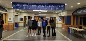 Students pose for a photograph under the KU Civic Engagement banner in the Kansas Union.