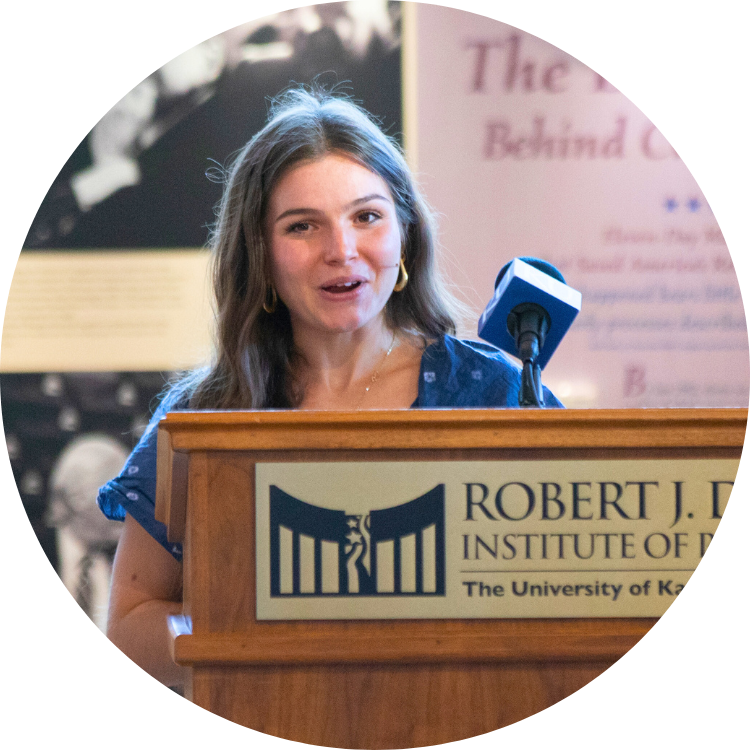 Ana Sofia Lahovary speaks while standing behind a podium and microphone.