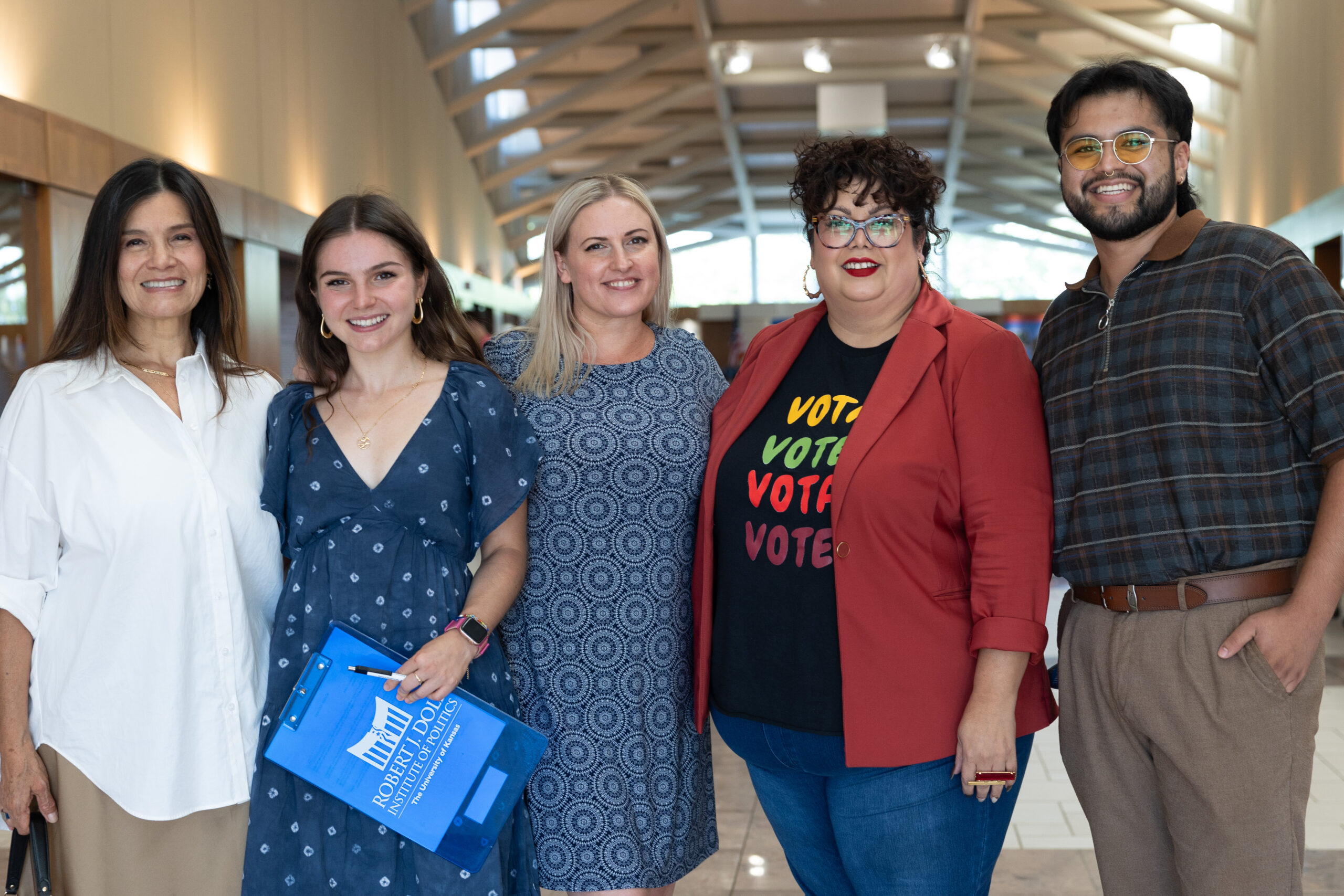 A group of people pose for a photograph in the Dole Institute's main hall.