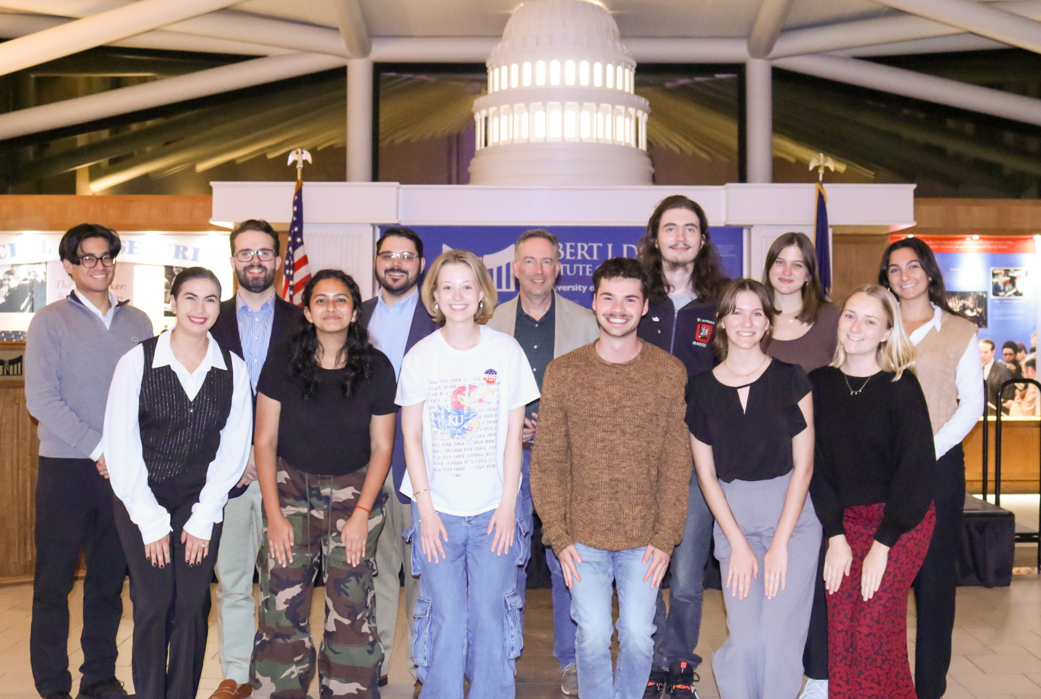 A group of people post for a photograph in the Dole Institute's main hall.